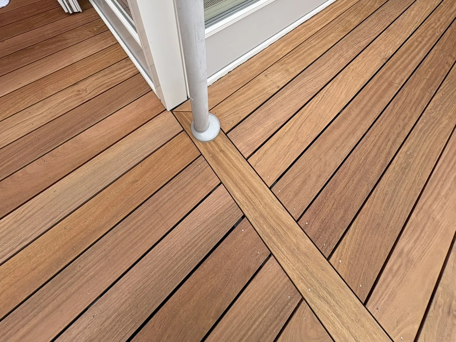 Præcis samling af terrassebrædder ved facaden og nedløbsrøret