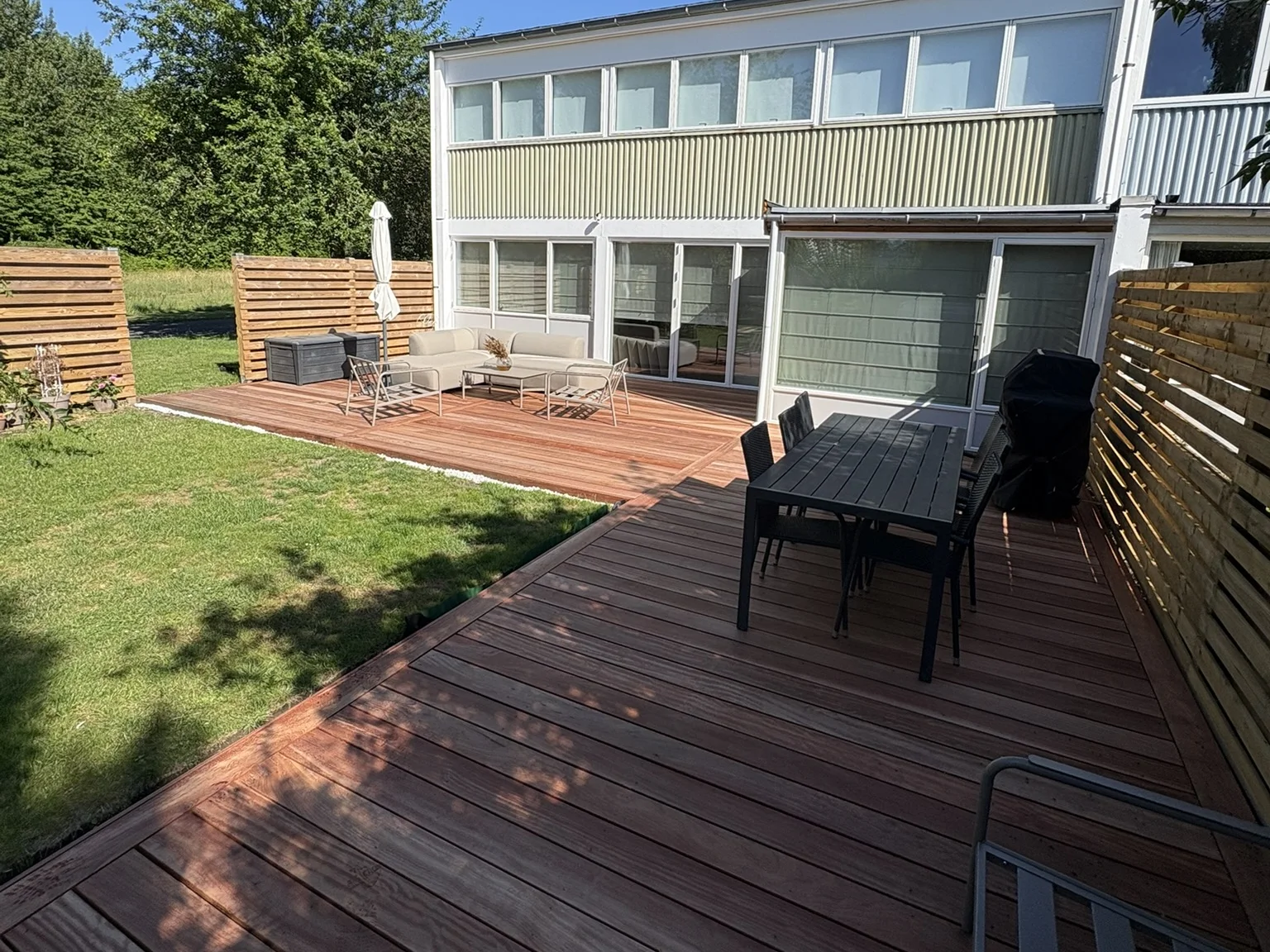 Færdig træterrasse i hårdttræ med spisebord, bygget af Kanu Byg